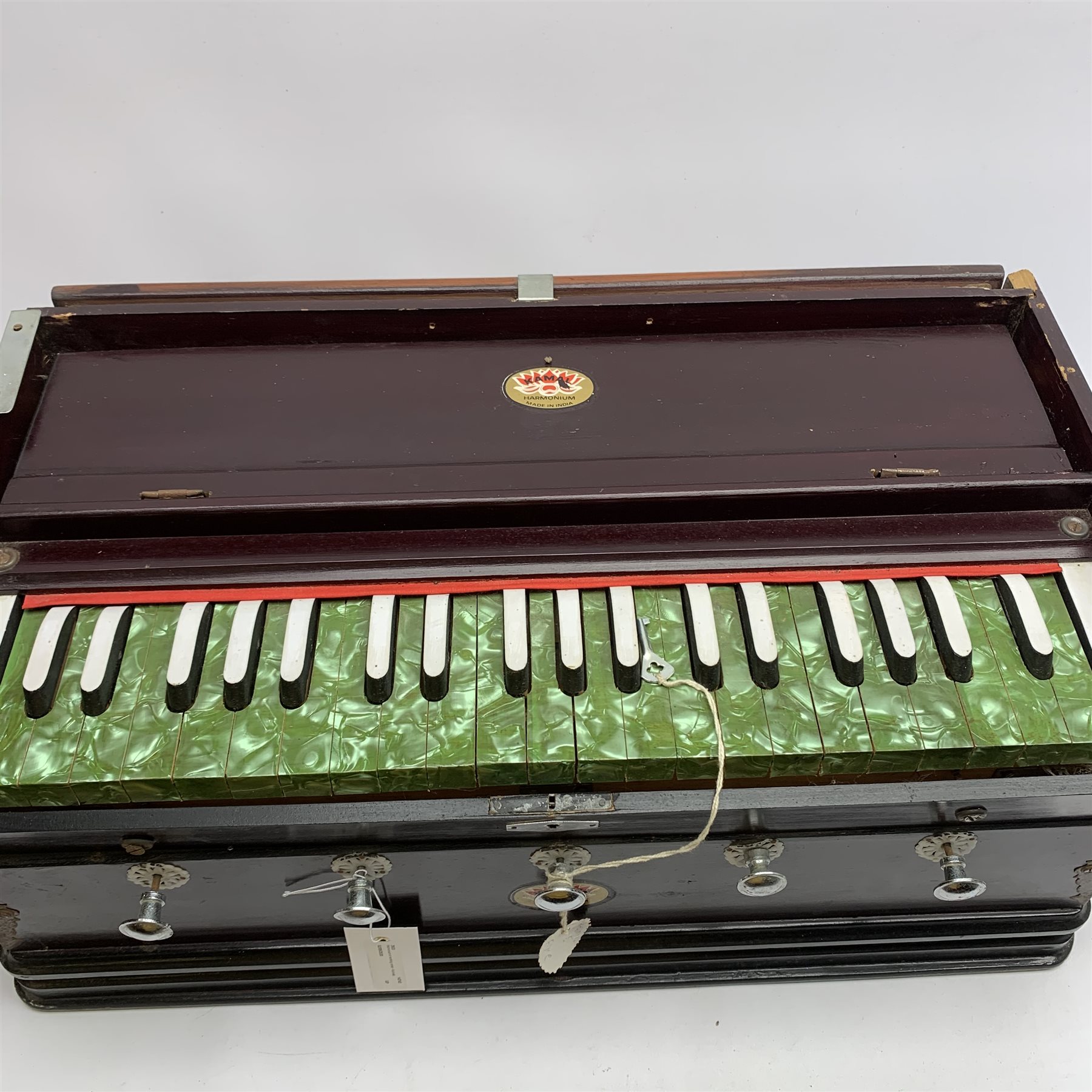 Indian portable harmonium by Kamala with mahogany stained wooden case and green pearline keys L56cm