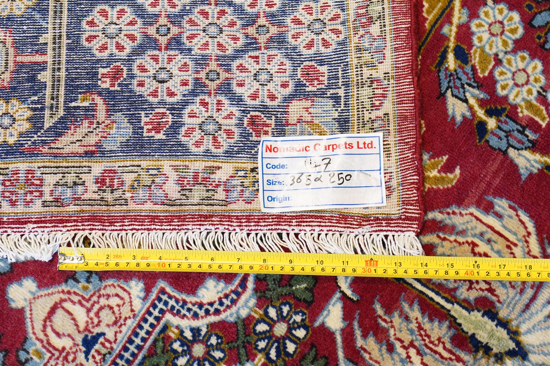 Central Persian Najafabad hand-knotted carpet, crimson field with a central elaborate cusped medallion with radiating floral motifs, surrounded by finely drawn scrolling vines incorporating stylized palmettes and rosettes, flowering plants and vase motifs, ivory spandrels similarly decorated enclosed by a dark indigo main border of floral arabesques between multiple guard stripes, with cotton fringe ends 