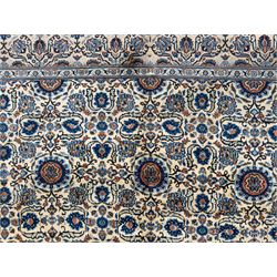 Northwestern Persian Tabriz hand-knotted carpet, the ivory ground with an all-over repeating Herati pattern of stylised palmettes, rosettes and serrated leaves in shades of indigo, terracotta and sky blue, framed by a dark blue border of arabesque vines and scrolling foliage between floral guard stripes, from the region of Tabriz