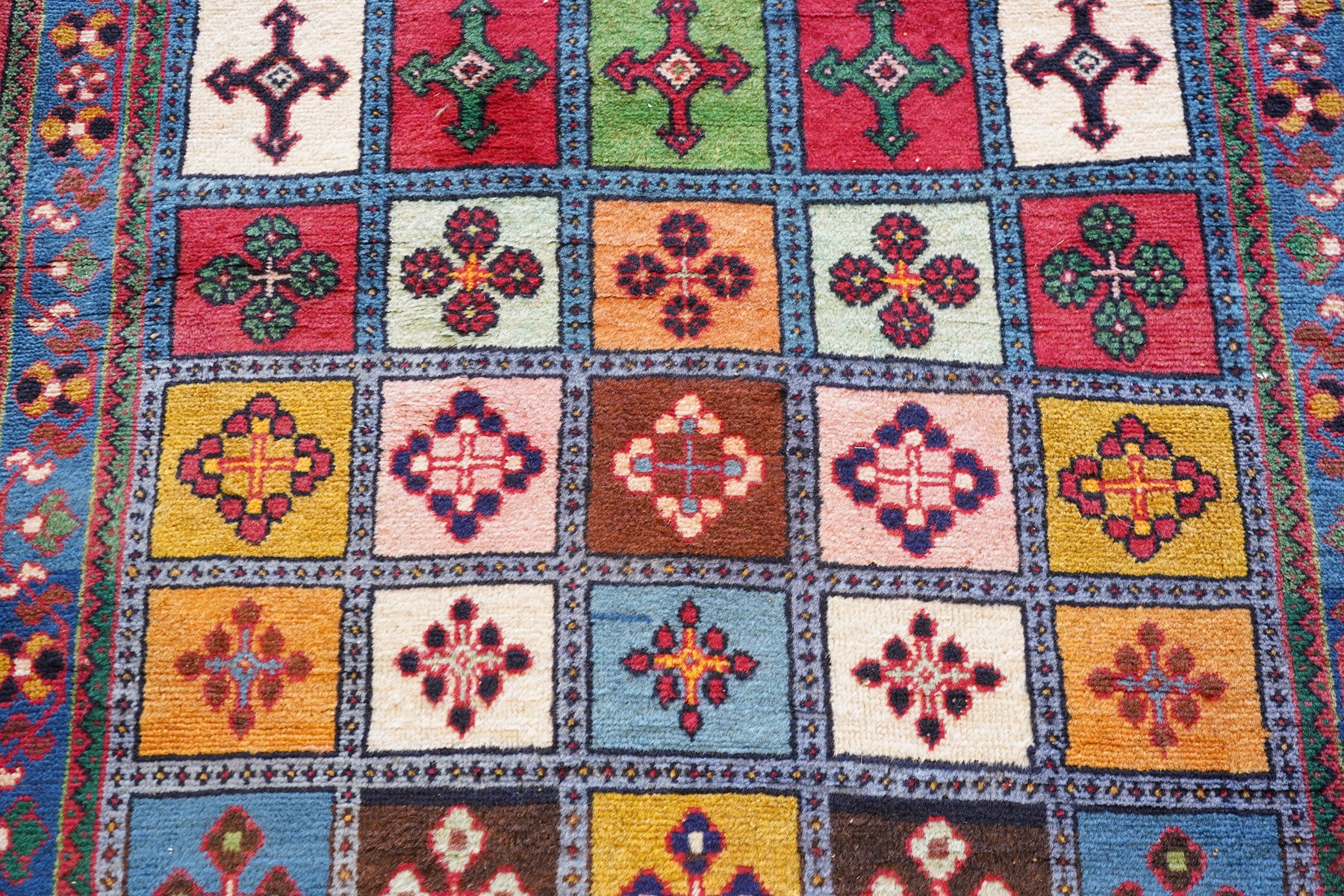 Persian Gabbeh indigo ground runner rug of garden design, the multi-coloured field decorated with five columns of panels in contrasting colours with stylised plant motifs, the guard band with trailing foliage