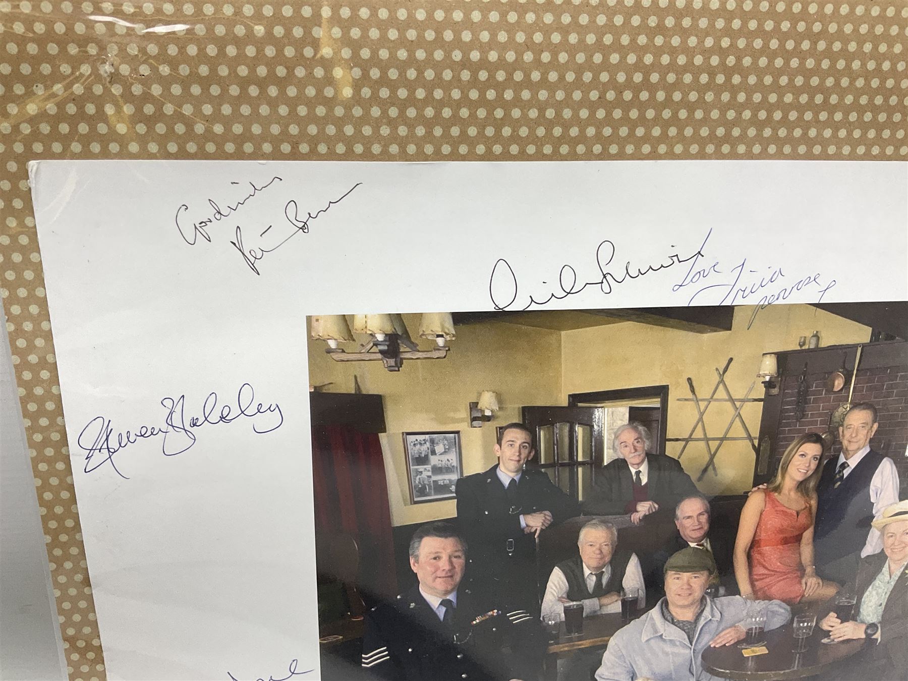 Photograph of the cast of Heartbeat posing in costume in the Aidensfield Arms and signed by twelve cast members including John Duttine, Tricia Penrose, Clare Wille, Derek Fowlds, Gwen Taylor, Lisa Kay, Peter Benson etc; unframed