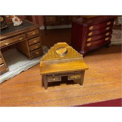 Good quality late 20th century dolls house by M. James dated 1995 in the form of a Beverley East Yorkshire Antique Shop called 'North Bar Antiques'; single-storey single-roomed shop with textured brick walls and flat roof, fully glazed hinged front with recessed hinged customer door and central window to the rear; comprehensively furnished with chests of drawers, pedestal desk, breakfast table, lowboy, two longcase clocks, delft rack with ceramics, occasional tables, pictures, Regency style mirror and collectibles; decorated walls with coving and picture rail and simulated floorboarding; wired for electric lighting; maker's plaque W61cm H42.5cm D41.5cm