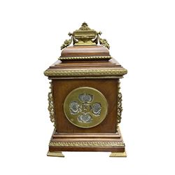 French - Early 20th century 8-day mantle clock in an oak case with pierced brass frets to the sides and raised on bracket feet, enamel dial with brass spandrels, Arabic numerals and a pierced centre, Two train rack striking movement, striking the hours and half-hours on a coiled gong. With pendulum and key. 