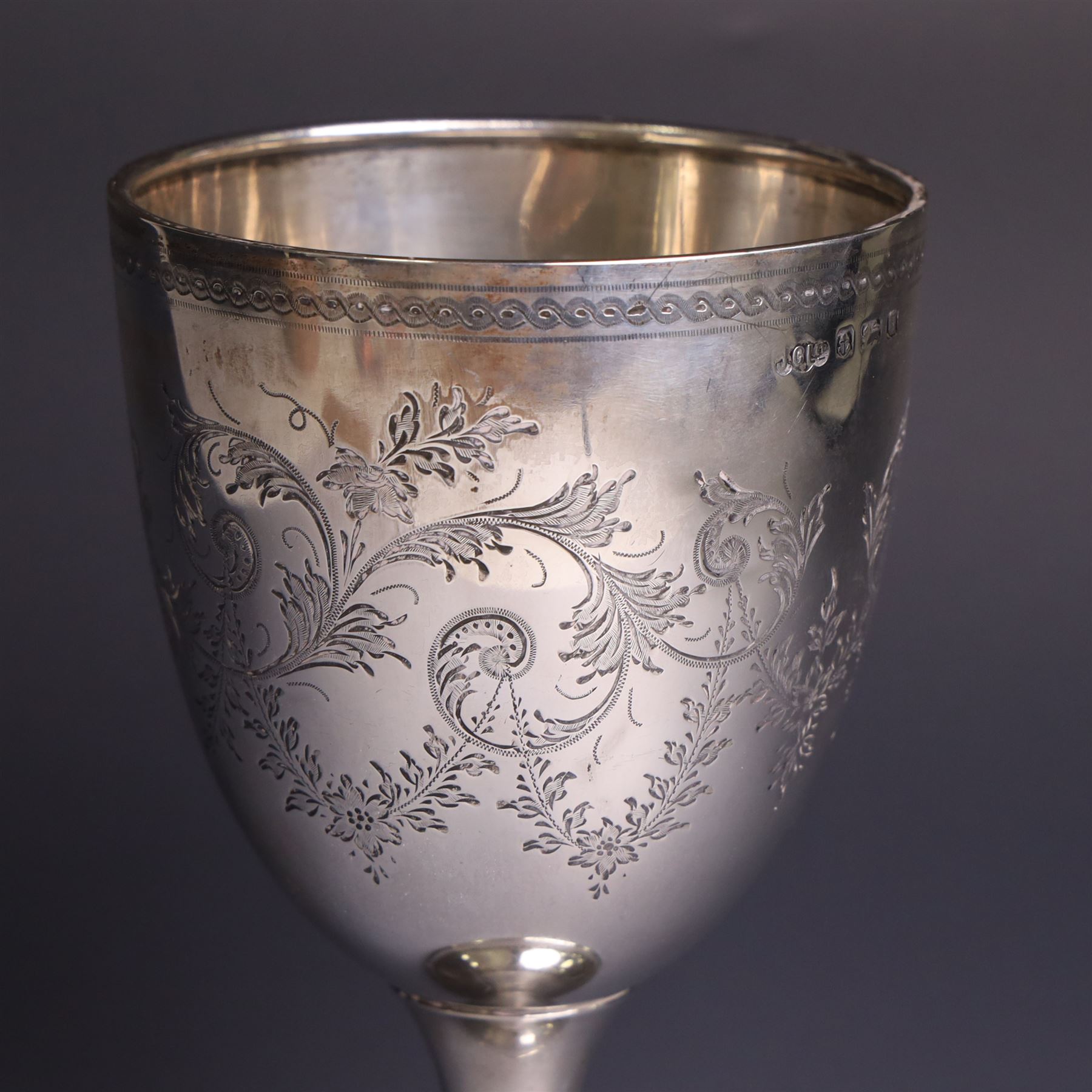 Early 20th century silver trophy cup, with engraved foliate and scrolling decoration upon a domed circular foot, hallmarked Joseph Gloster Ltd, Birmingham 1919, H18cm