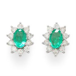 Pair of 18ct white gold emerald and diamond cluster earrings, each stud set with a single ...