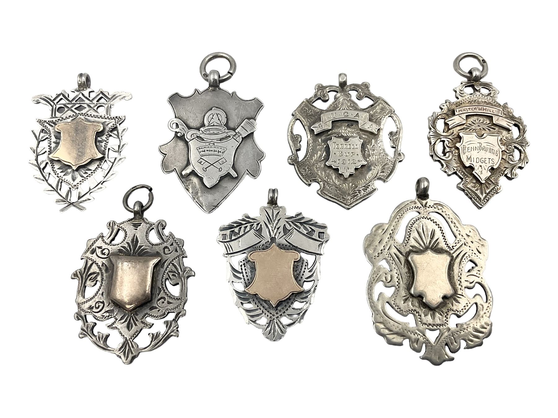 Seven Edwardian and later silver cartouche fobs, to include five gold faced examples and three double sided examples, all hallmarked with various dates and makers

