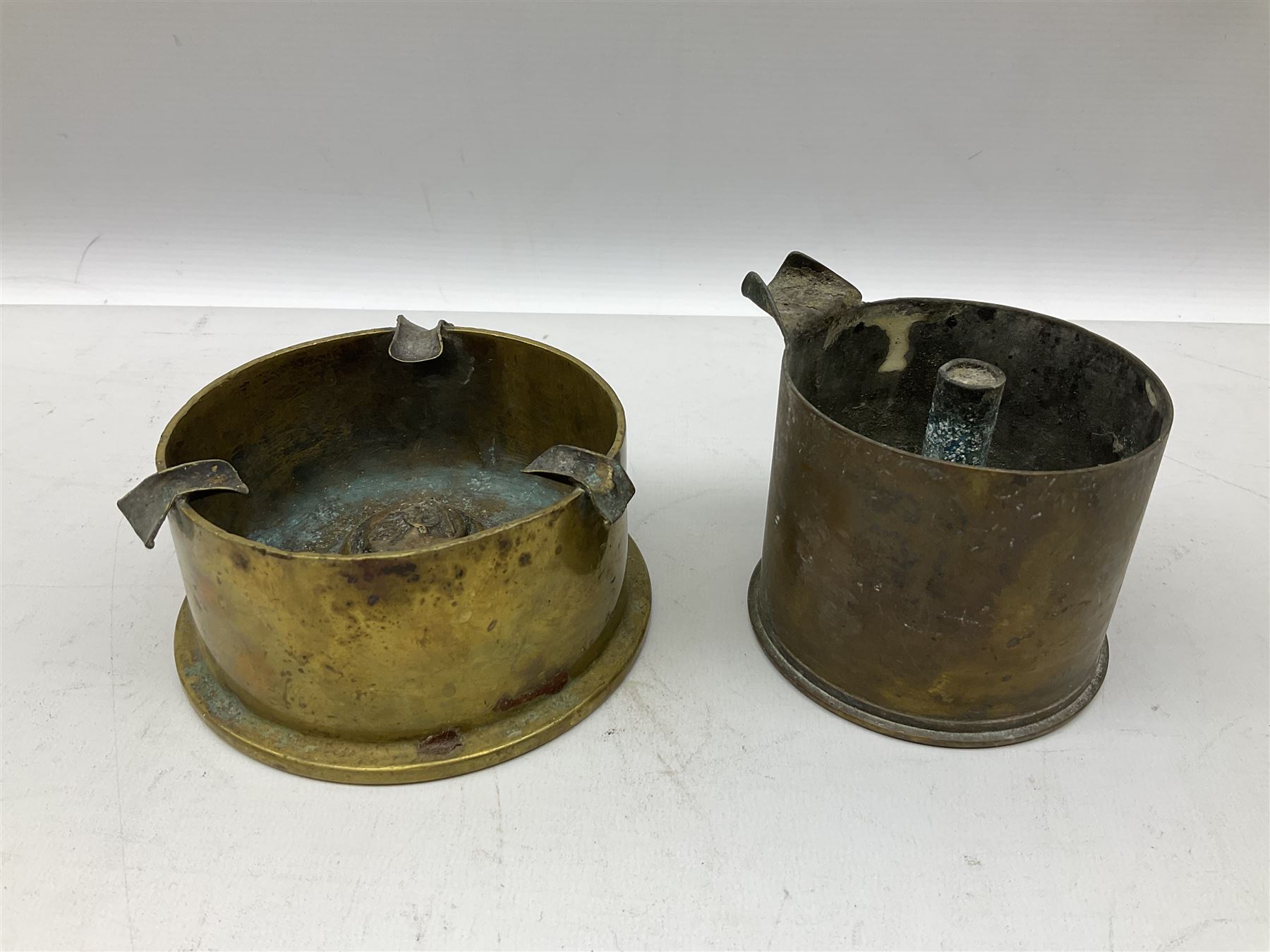 Trench Art - three WW2 brass shell case ashtrays, one mounted with Royal Artillery cap badge and button and one mounted with RA button; together with a pair of place name holders each formed from a Royal Artillery cap badge (5)