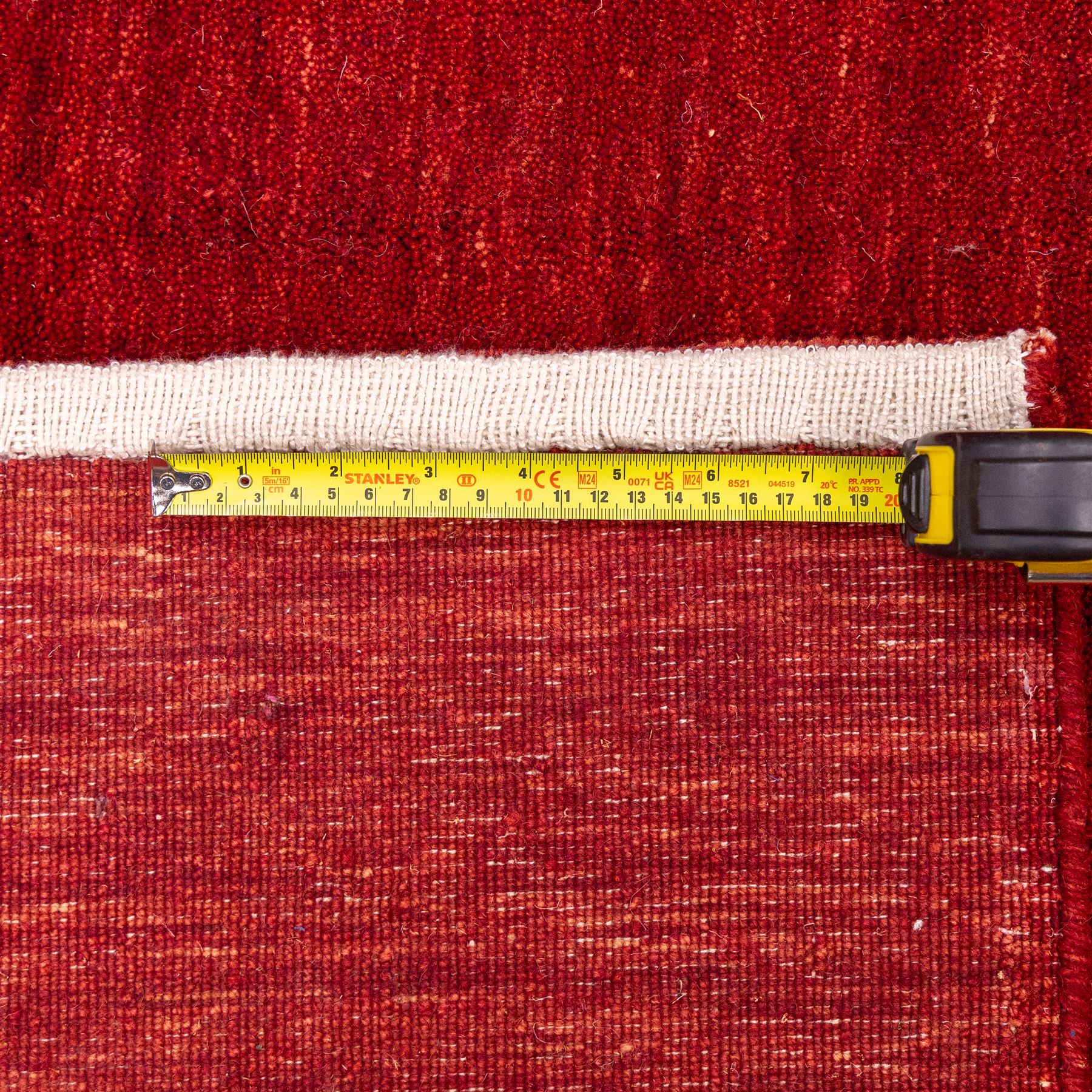 Two contemporary Moroccan Berber hand-woven rugs, deep madder red field of plain design, 199x153cm, other with deep madder red field with a simple lattice of ivory lines forming panels with some tonal variation, 190x146cm 