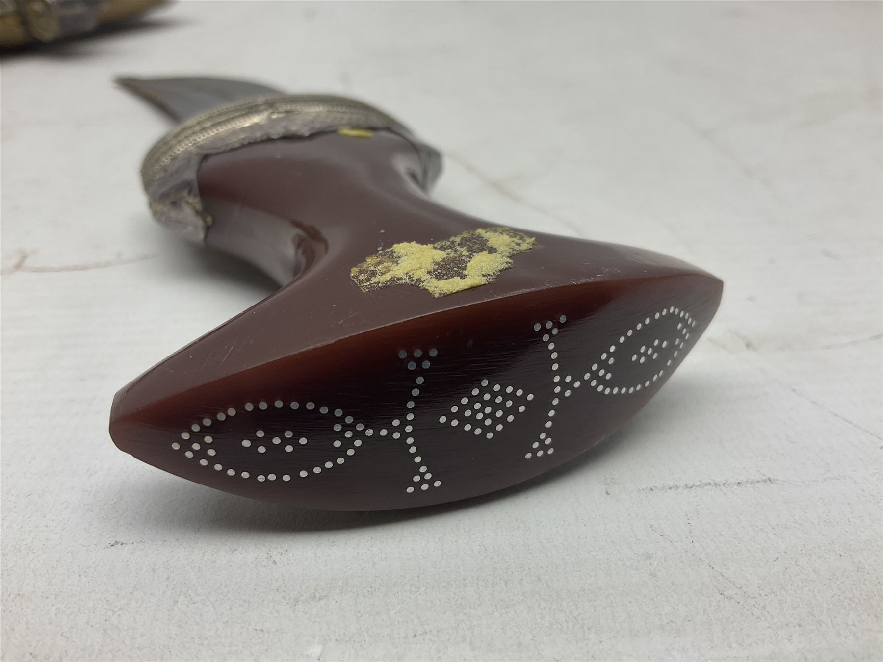 Omani Khanjar dagger, the 12.5cm curved blade with pronounced medial rib to either side, waisted horn style hilt with dome shaped pommel and inlaid pique work; in an intricately filigree decorated white metal scabbard with rings woven into the belt mount L25cm overall