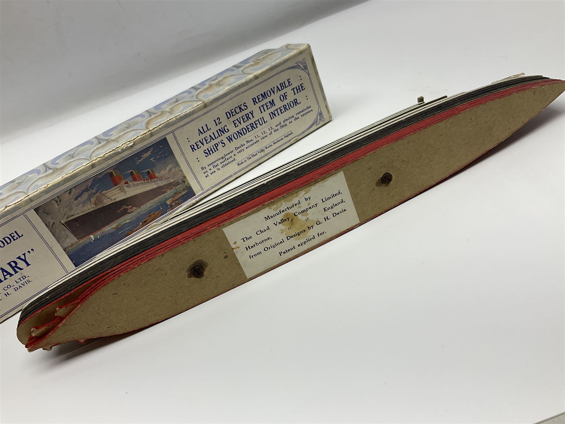 Chad Valley 'Take to Pieces' model of R.M.S. Queen Mary; made up of thirteen removable decks revealing the interior, held together by nuts/bolts to the top deck; boxed with original key chart sheet
