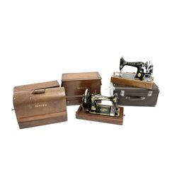 A group of five cased Singer sewing machines. 