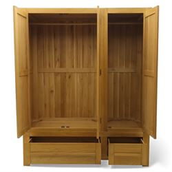 Modern light oak triple wardrobe,  three panel doors with integrated handles enclosing full-height hanging rails, the lower section fitted with two flush-front drawers, square uprights