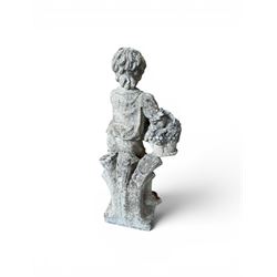 Weathered cast stone garden figure depicting a child holding a fruit basket
