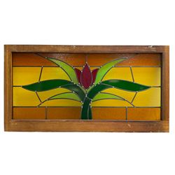 Collection of leaded stained glass window panes in mahogany frames, depicting central stylised tulip flower in green and red within an amber and yellow field, mottled and plain glass, in various sizes (single panes: 118cm x 62cm & 127cm x 62cm; triptych panes: 182cm x 62cm & 194cm x 62cm & 196cm x 62cm; four panel pane: 209cm x 62cm; smallest single panel: 43cm x 62cm)