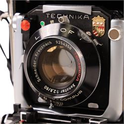 Linhof Tecnika 70 medium format press camera serial no. 1711919, with a Xenotar 1:2.8/80 lens serial no. 9254350 and a Symmar 1:5.6/180 lens serial no. 8357904, both coupled to the camera, and additional accessories including Symmar-S 5.6/100 lens, and a Carl Zeiss Jena Apo-Lanthar 40mm1:4.5 macrolens, numbered set of seven Linhof dark slides, super rollex roll film holder and anatomical grip, all contained within modern case
