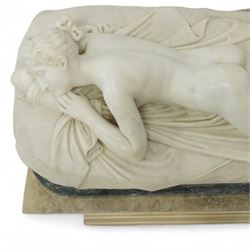 After Antonio Canova (Italian 1757-1822): 'Sleeping Venus', an Italian carved white marble figure of a reclining nude, the serene figure depicted lying on her side, her head resting on a cushion and one knee gently raised, a loosely draped sheet partially covering her lower body, on a rectangular base with rough-hewn surround, raised on a marble plinth over a sarcophagus style pedestal, circa 1900

Provenance: Kirkham Hall

Notes: A late-19th-century homage to Canova’s neoclassical models, reflecting the Grand Tour taste for idealised classical beauty and the refined finish characteristic of Italian workshop marbles of the period