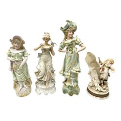 Late 19th century continental spill vase as a young girl standing beside an open tree trunk H21cm; and three German bisque figures (4)