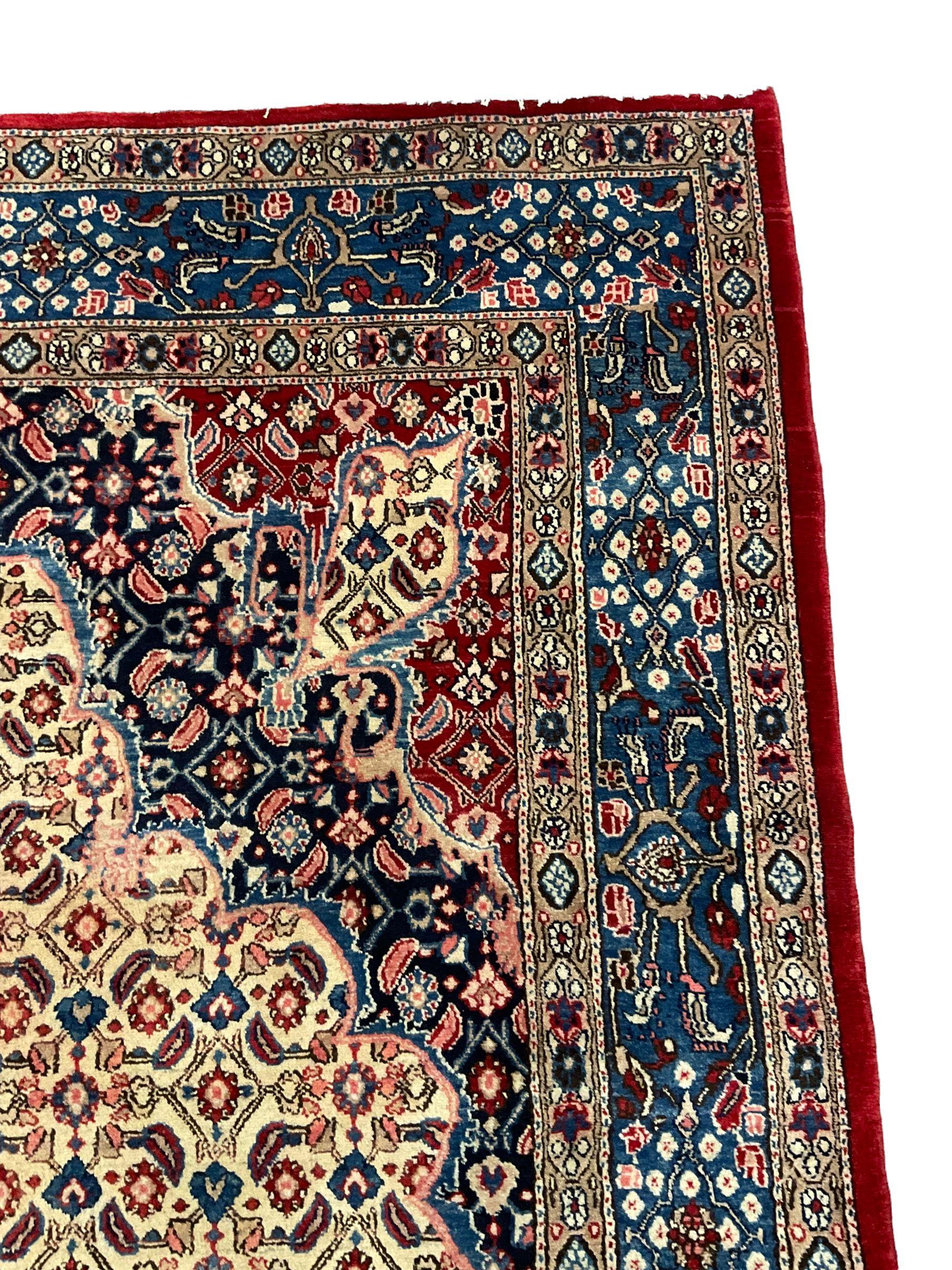 Persian Moud carpet, the field decorated all-over with Herati motifs, central medallion and spandrels decorated with stylised plant and flower head motifs, repeating border with guard
