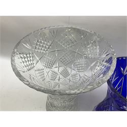 Heavy bohemian blue overlaid cut glass vase of waisted form with hobstar decoration and star cut base, together with a larger clear vase of similar form with flared rim, tallest H35cm