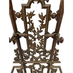 19th century cast iron hallway hat and coat stand, the arched frame decorated with overlapping foliage, central oval mirror surrounded by trailing oak leaves and acorns, with extending umbrella and stick strand, the curved plinth base decorated with acanthus leaves, with impressed and mounted R.d. lozenges