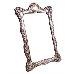 Modern silver dressing table mirror, with rectangular bevelled mirror plate, surrounded by silver frame, embossed with flowers and C scrolls, with easel style support verso, hallmarked Carr's of Sheffield Ltd, Sheffield 1993, H38.5cm