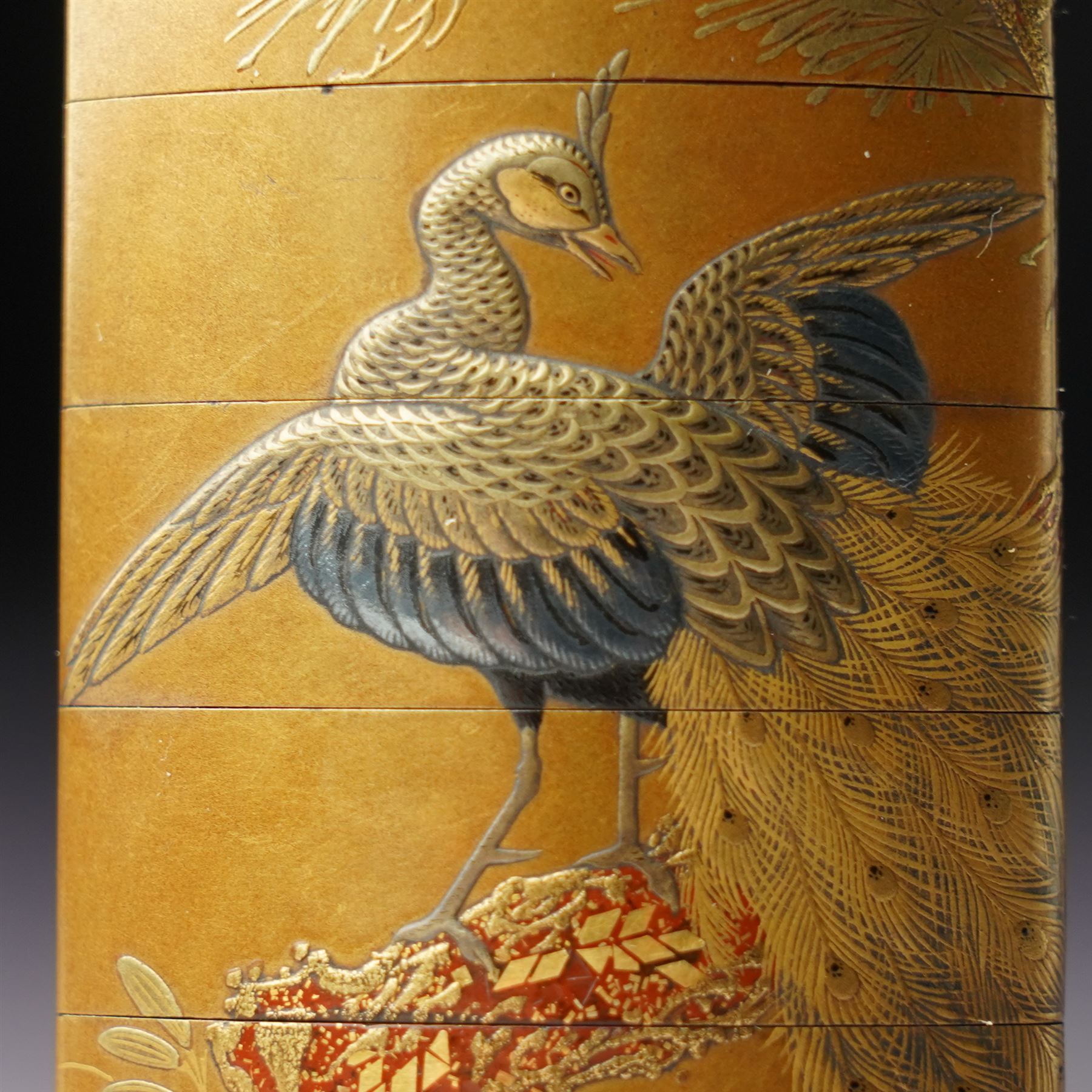 Minsetsusai Kyūho - Fine Japanese Meiji period gold lacquered four-case inro, of rounded rectangular form, the body with maki-e decoration depicting a peacock on a branch, the internal body with nashiji lacquer, artist's two character signature and kakihan to base, H6.5cm
Notes: For the artist, see see E. A. Wrangham, The Index of Inro Artists, Harehope, Northumberland, 1995, p. 158.
An inro would be an essential element of a gentleman's kimono, which typically lacked pockets. The stacked compartments could be used to hold medicine, which was particularly useful for Samurai warriors going into battle. 