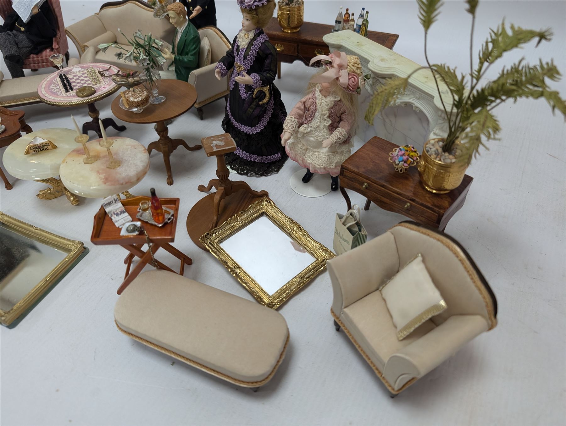 Dolls house furniture, including sofa, chairs, foot stools, fireplace, sideboards, five figures, mirrors, paintings and accessories