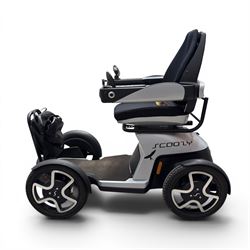TGA Scoozy - mobility scooter, four wheel model with joystick controls, front storage bag, lights and grey and black bodywork.
