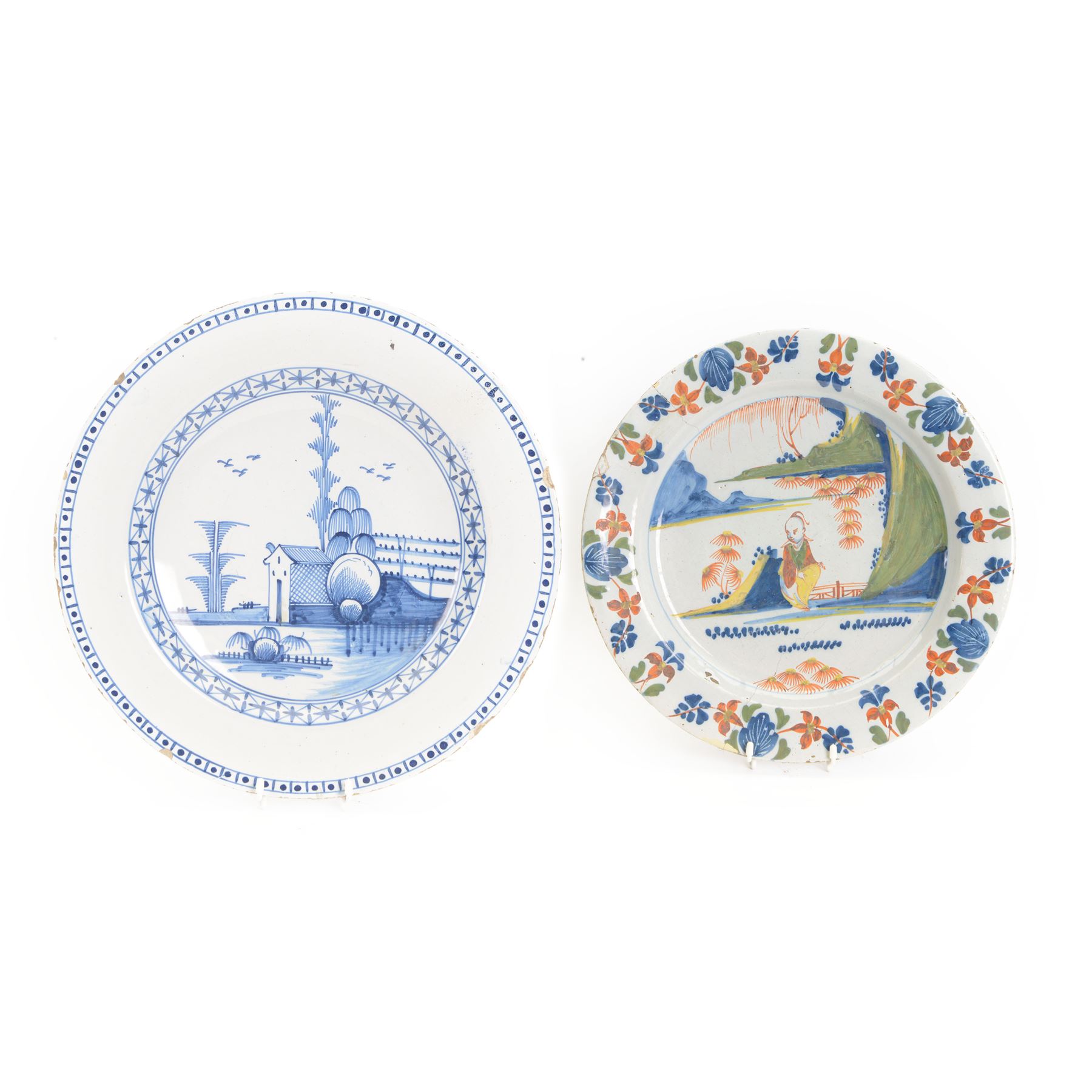 Mid 18th century Lambeth Delft plate, probably from the Abigail Griffith factory, circa 1750, painted in polychrome enamels with a figure seated in a landscape, within a garlanded border of flowers to rim, D34cm, together with a Liverpool Delft plate, circa 1760, painted in blue with a boathouse surrounded by trees by a river, within diaper and cell borders, D37cm