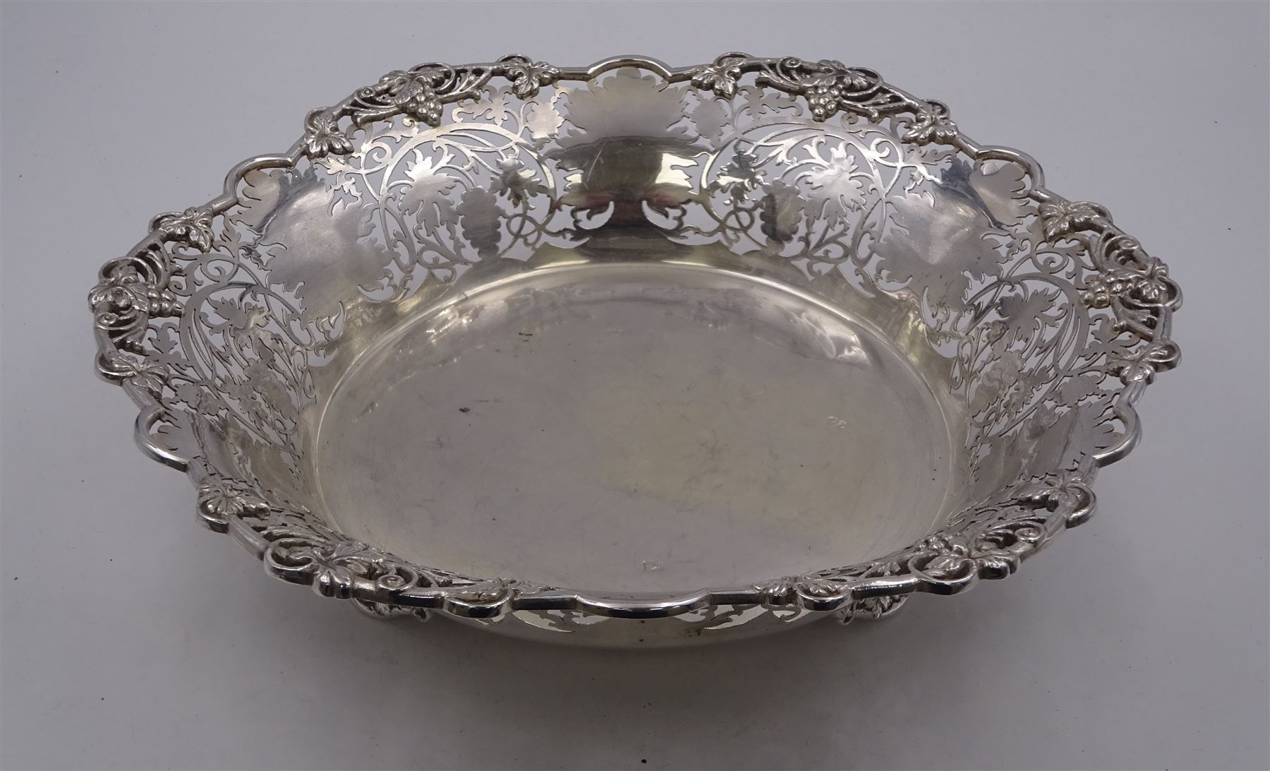 Modern silver Britannia standard fruit bowl, of lobed circular form, with applied and pierced fruiting vine decoration throughout, upon three bracket feet, hallmarked 1966, maker's mark BSC