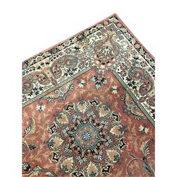 Persian design peach ground carpet, central floral medallion surrounded by scrolling foliage, decorated all over with stylised plant motifs, floral design repeating border