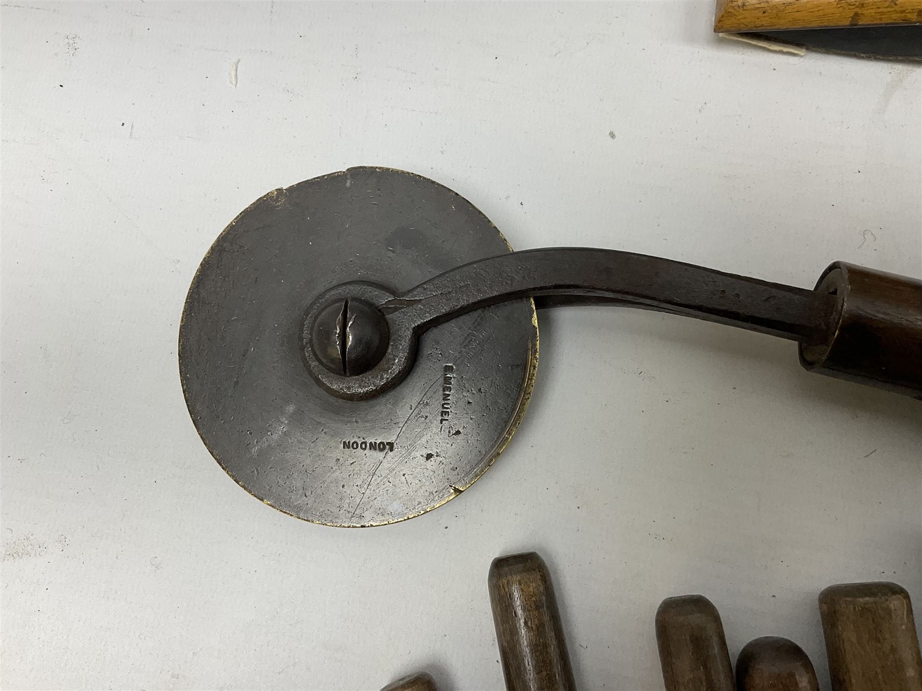 Thirty-one bookbinder's brass number and letter stamps, predominantly with beech handles, together with a bookbinder' decorative fillet roll, with brass triple line wheel stamped E. Menuel London, with wood handle, and two ink blotters