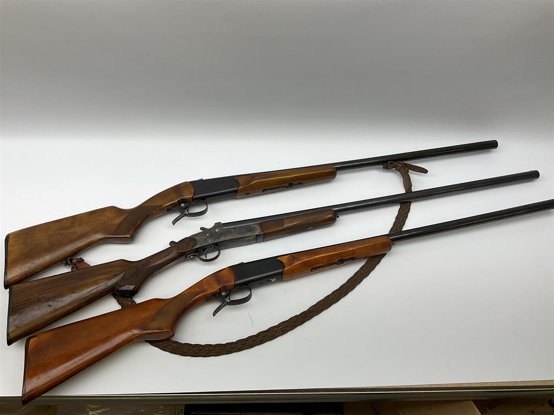 Three 12-bore single barrel sporting guns - Russian Baikal with 72.5cm barrel and underlever opening, serial no.Y17440, L114cm overall; Russian Baikal with 72.5cm barrel and underlever opening, serial no.A23484 L114cm overall; and Spanish with 76.5cm barrel and top lever opening, serial no.38996MU L118.5cm overall (3) SHOTGUN CERTIFICATE REQUIRED