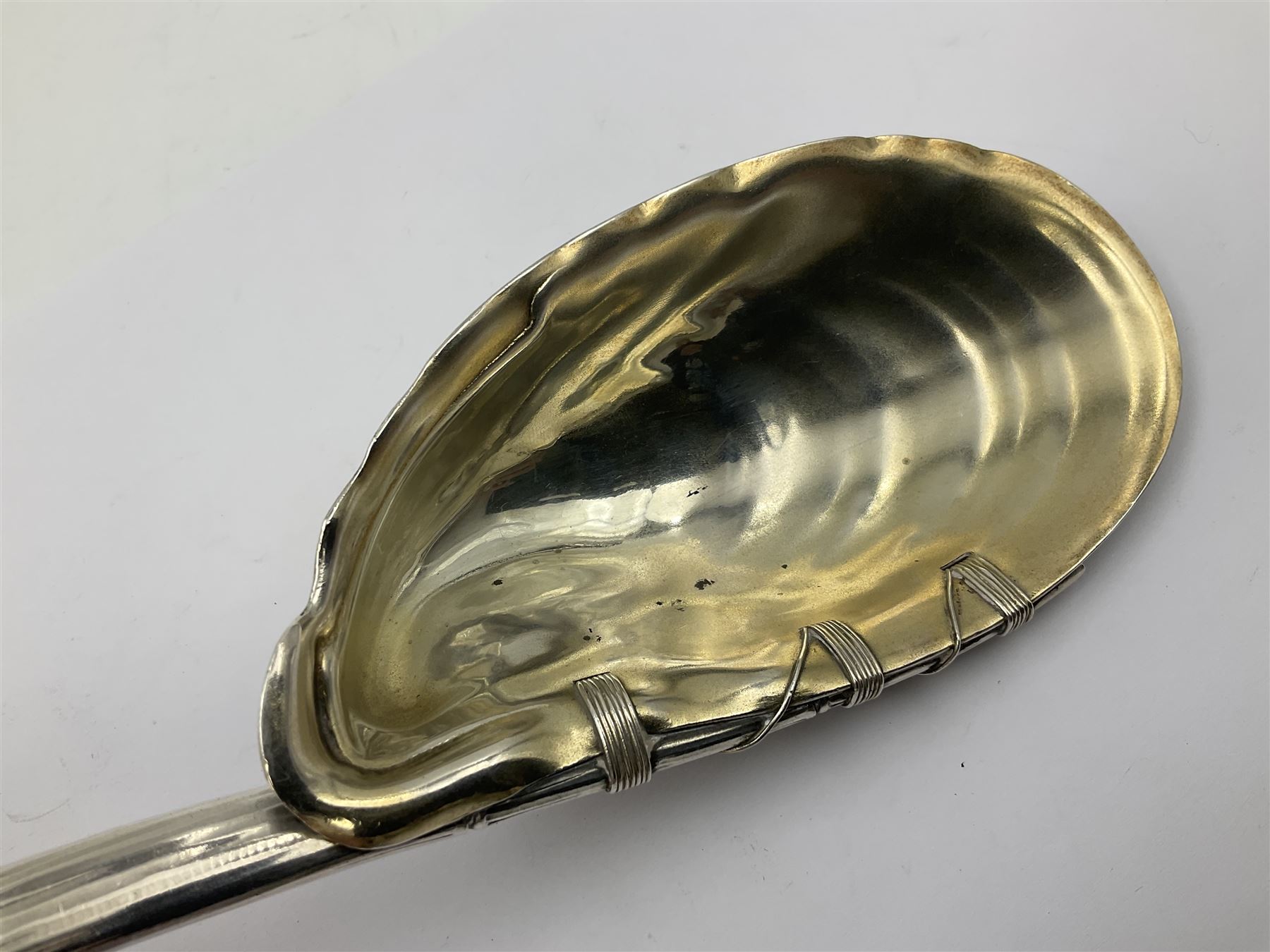 Mid/late 19th century Gorham silver serving spoon, circa 1863-1890, the bowl modelled as an oyster shell with silver gilt interior, affixed to the bamboo handle with silver twine, the bowl with marks for Gorham and impressed Sterling 330, L26.5cm
