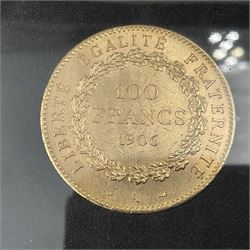 France 1906 gold one-hundred francs coin, housed in a display case