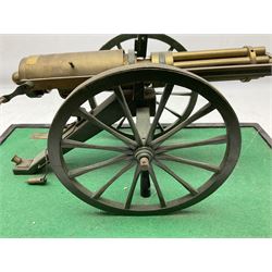 Scratch built brass model of an 1861 Gatling Gun with rotating barrels, hinged cover revealing mechanism, on metal bound wooden spoked wheels and rectangular base L47cm H22cm