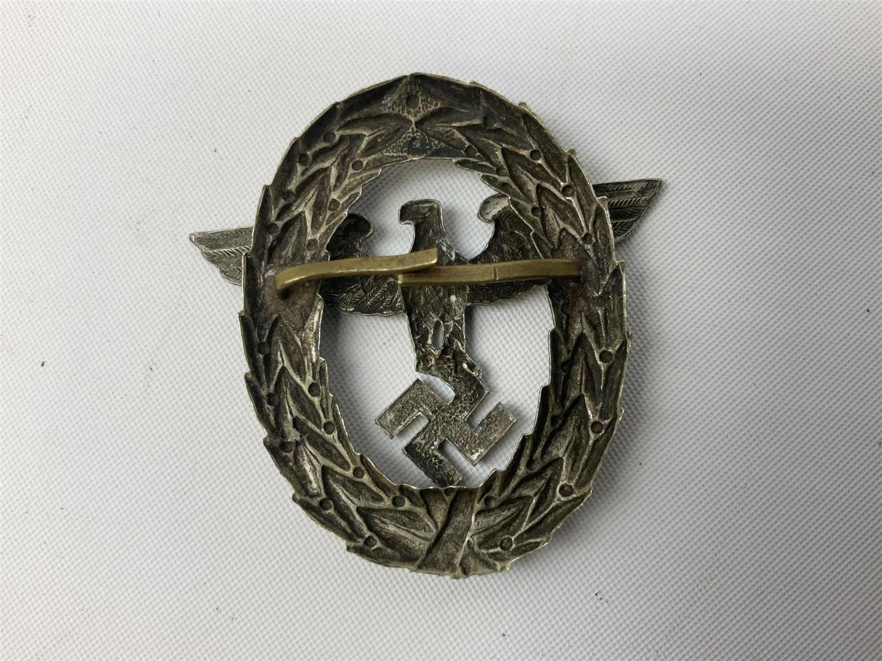 Three WW2 German visor cap badges comprising Police eagle, Political leaders eagle and Norwegian Quisling Party; all with fixings; and WW2 Polish visor cap badge (4)