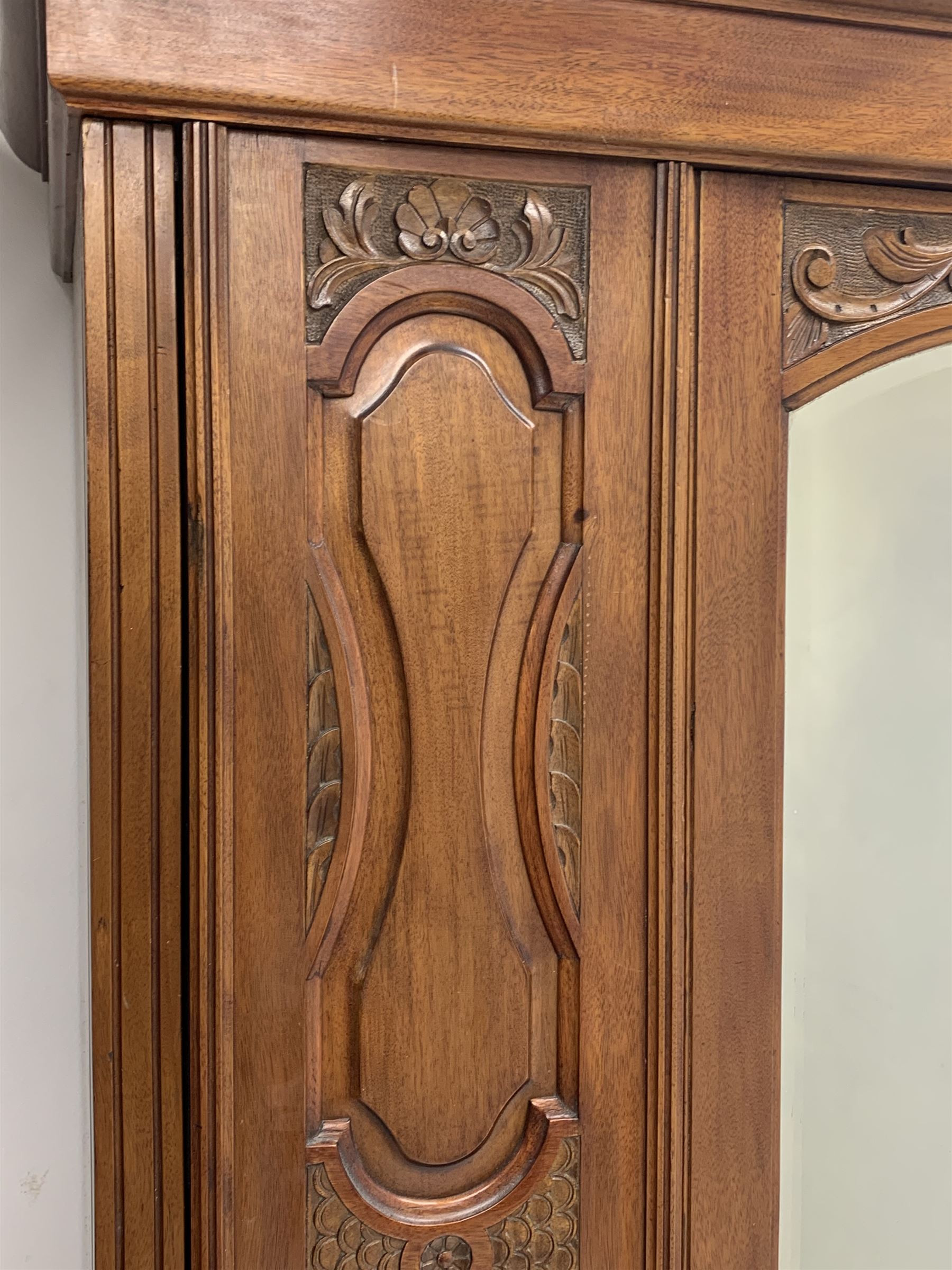 *Edwardian walnut narrow single wardrobe, projecting cornice over single bevelled mirror glazed door, panelled front carved with shells and flower heads, base fitted with single drawer, W90cm, H202cm, D54cm