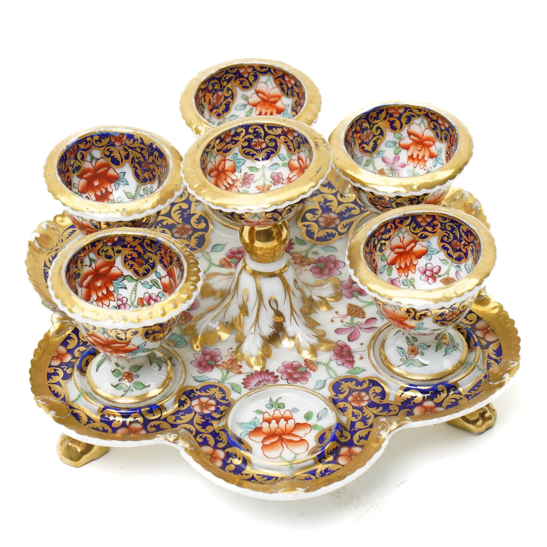 Early 19th century Chamberlain's Worcester egg stand of serpentine circular form fitted with five egg cups and decorated with flowers on a blue and gilt ground with gilt border and on paw feet D20cm. Printed mark used on the Regent body circa 1811-1820 
Provenance: property of a Nobleman
