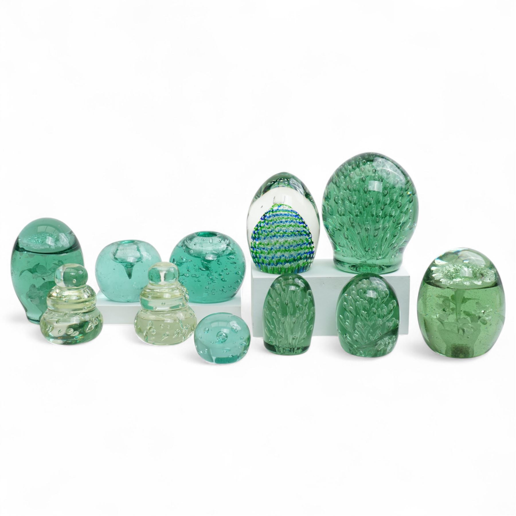 Eleven Victorian and later green glass dump paperweights, with floral and bubble inclusions, largest H14cm 