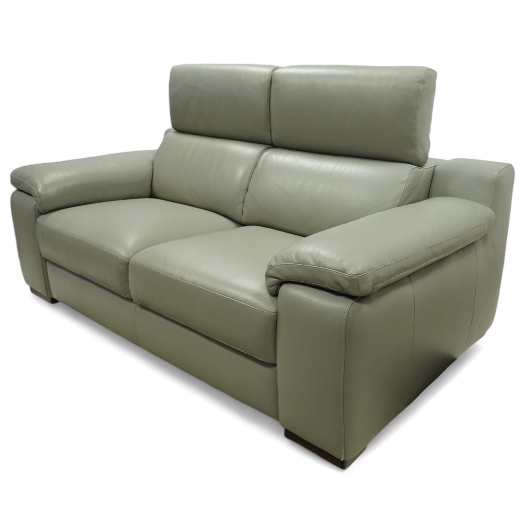 Modern Italian style leather two-seat sofa, upholstered in pale grey leather with panel stitched cushioning, with retractable head rests and broad arms, raised on square feet
