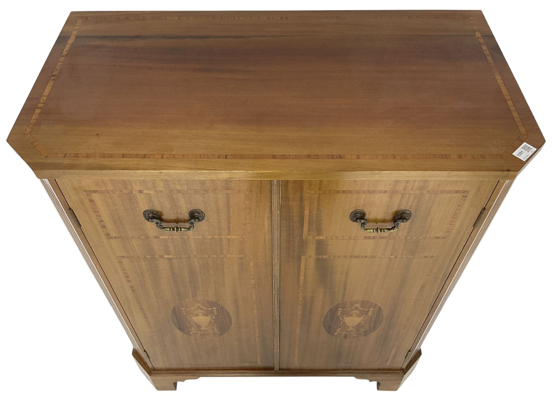 John More of Scarborough -  Edwardian Revival 'Canterbury Cabinet' inlaid mahogany cabinet, fitted with double cupboard decorated with urn motif inlays and banding, flanked by canted fluted uprights, on bracket feet