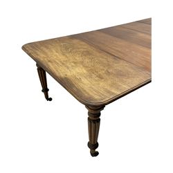 Early 19th century figured mahogany extending dining table, the rectangular top with moulded edge and rounded corners, pull-out action with three additional leaves, raised on turned and lobe carved supports with brass cup castors