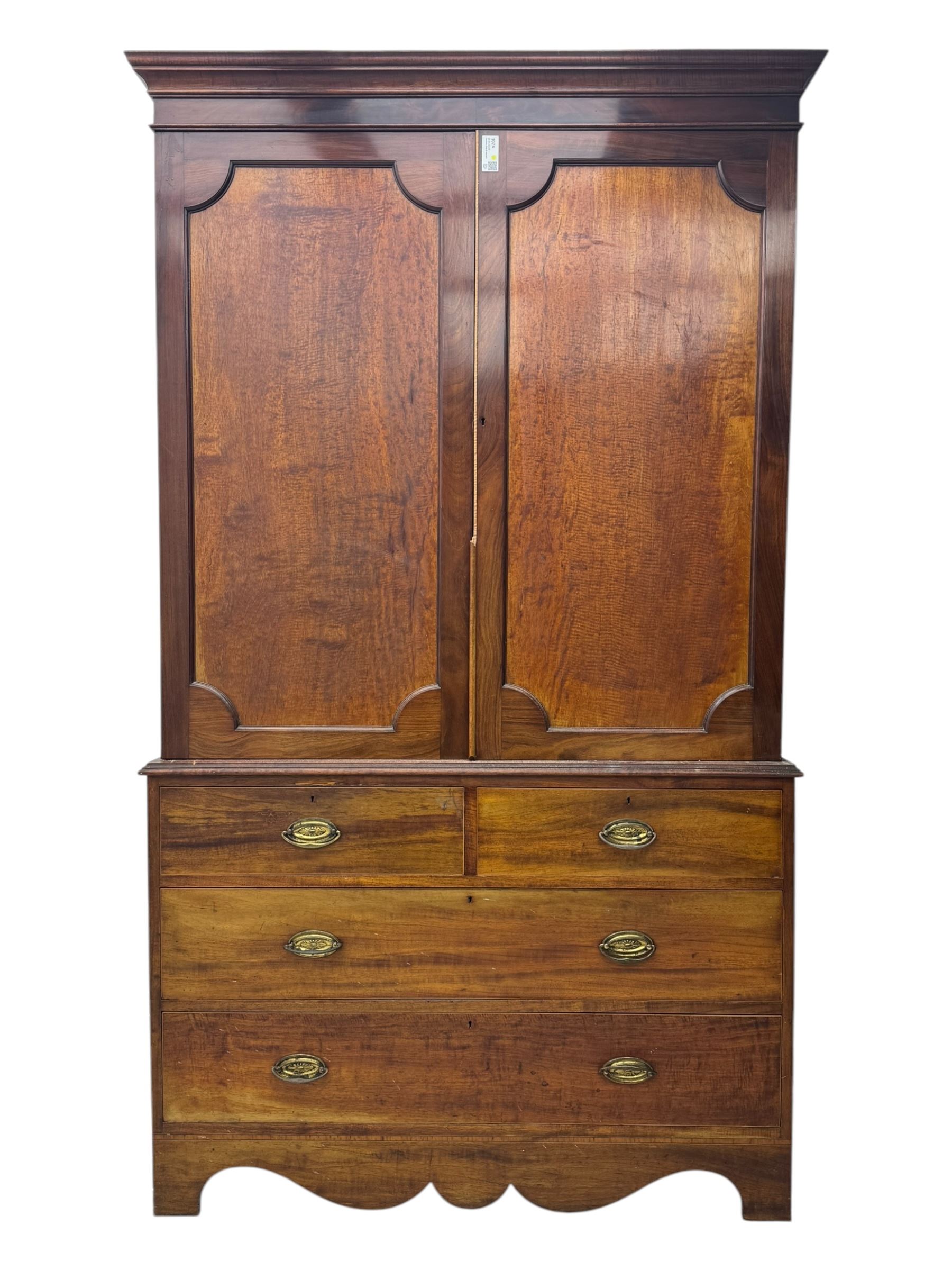 George III mahogany linen press cupboard, projecting moulded cornice over two panelled doors, the interior fitted with two slides and shelf, two short and two long drawers below, shaped apron over bracket feet 