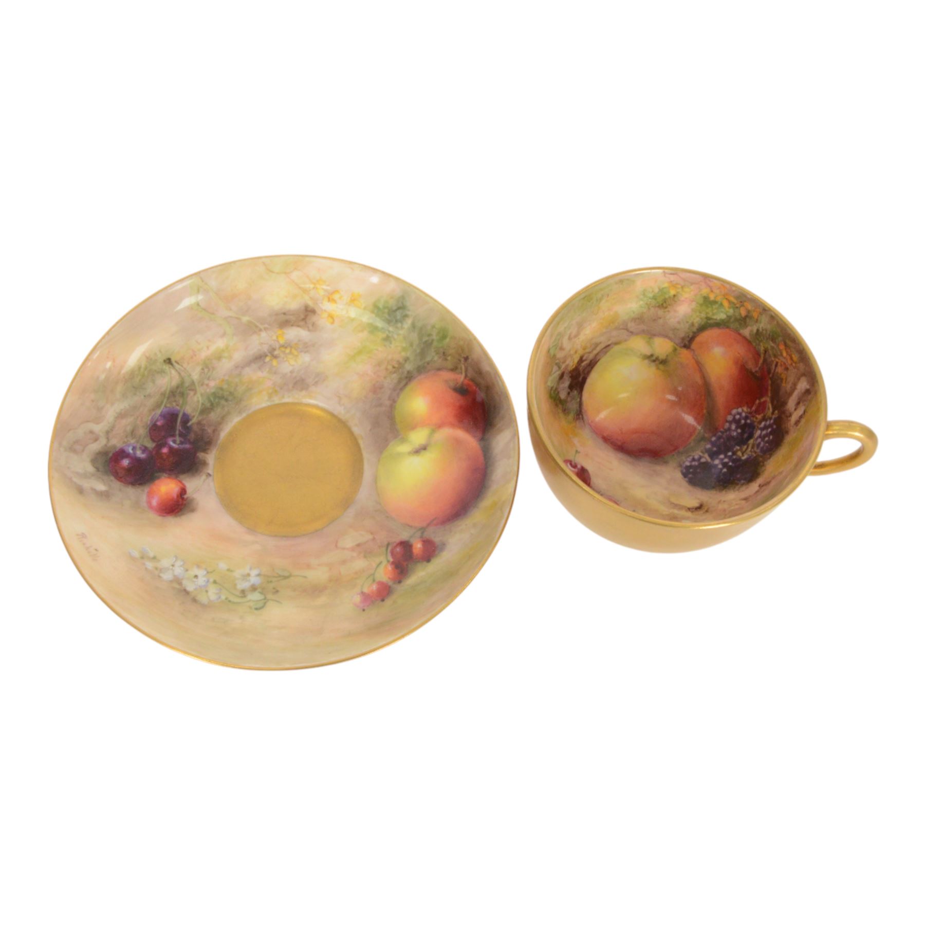 Royal Worcester fruit painted cabinet teacup and saucer, interior hand painted with apples, blackberry and cherries upon a mossy ground, the cup exterior and centre of saucer gilded, cup and saucer signed Rickells, each with puce coloured printed marks beneath, H7cm