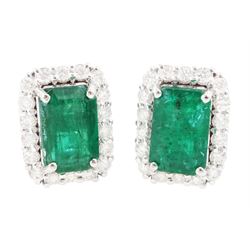 Pair of 18ct white gold emerald and diamond cluster earrings, each stud set with a single ...