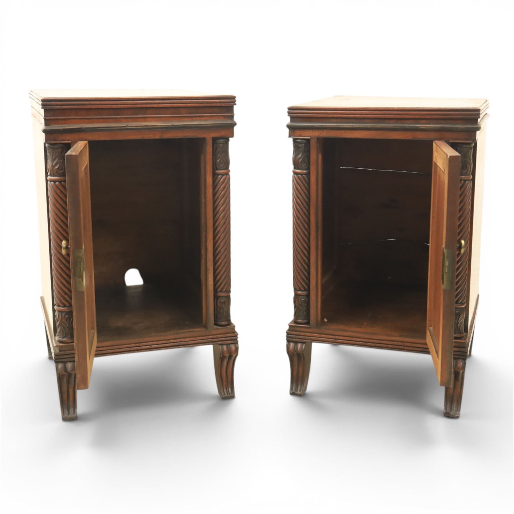  Pair of Regency mahogany bedside cabinets, rectangular top above a central cupboard door with flame mahogany veneer, flanked by spirally turned column uprights, raised on shaped supports