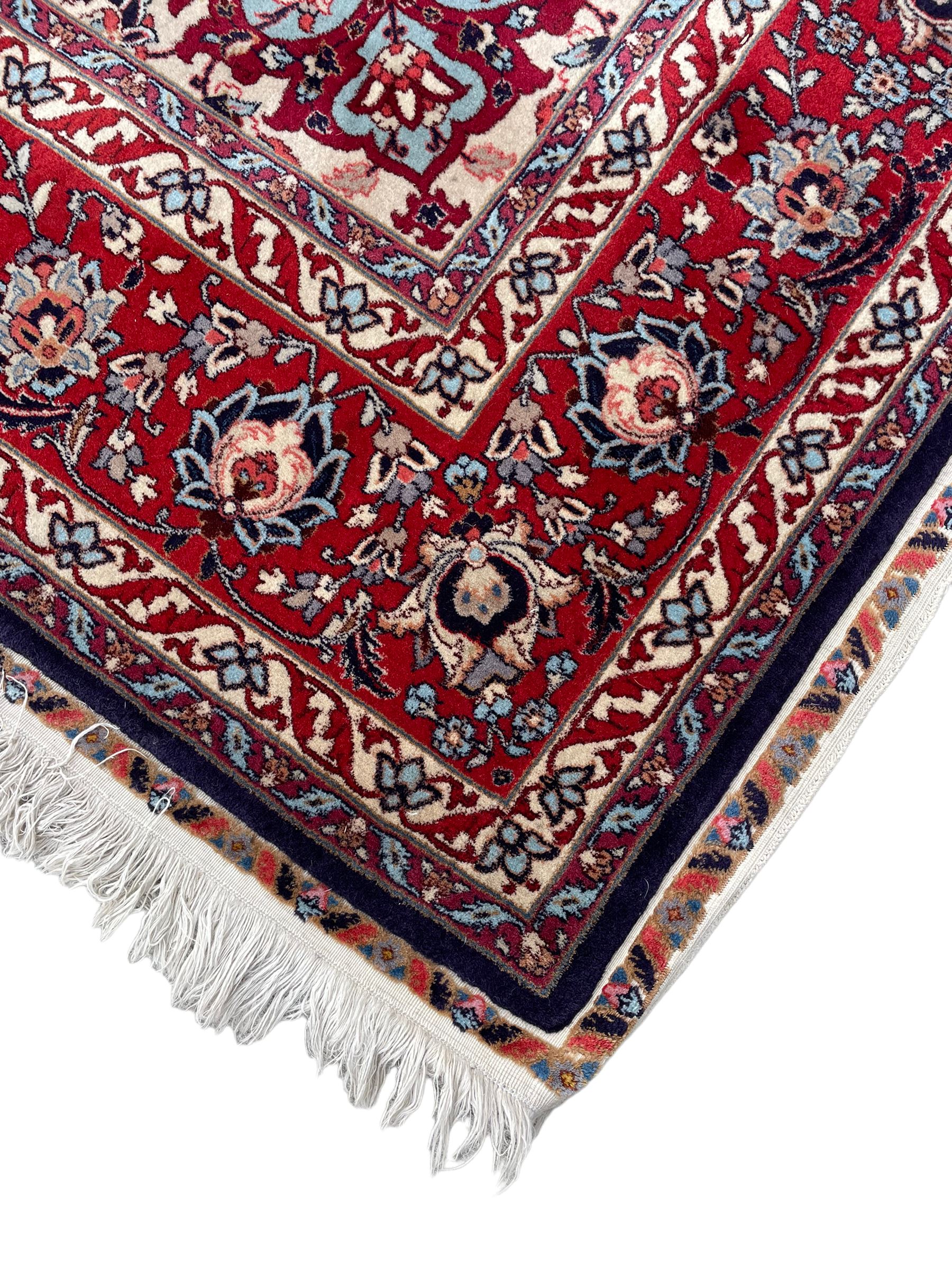 Persian Hamadan indigo ground rug, central floral crimson pole medallion surrounded by trailing foliate decoration and stylised plant motifs, the main guarded border with repeating stylised flower heads, densely knotted