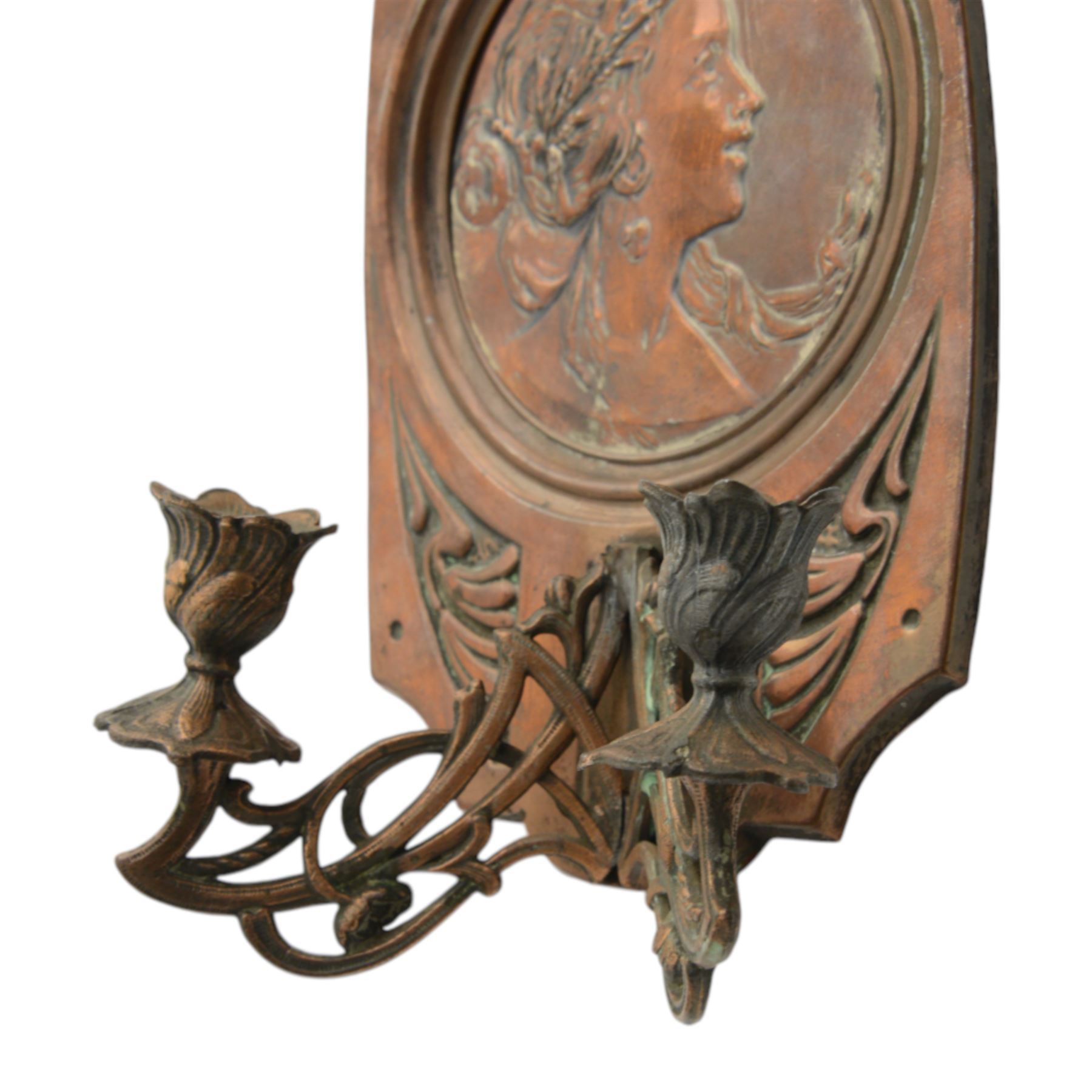 Pair of late 19th/early 20th century Art Nouveau copper twin branch wall sconces, each with shaped back plate chased with a central panel of a maiden in profile above and surmounted by foliate motifs, supporting two foliate open cast branches with bud sockets above conforming drip pans, H31cm W16cm D8.5cm
