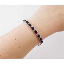 18ct white gold sapphire and diamond bracelet, twenty-three oval cut sapphires, each spaced by two round brilliant cut diamonds, stamped 750, total sapphire weight 14.785 carat, total diamond weight 0.88 carat